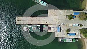 Ferry carrying cars and passengers across the sea, top down aerial drone view. Ferry on the lake, transporting cars