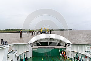 Ferry crew prepares to dock at harbor and open front end of ferry for unloading