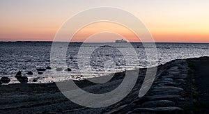 A ferry on the horizon at sunset.