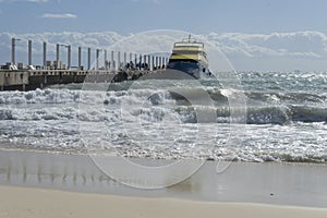 A ferry moored at a dock crowded with tourists