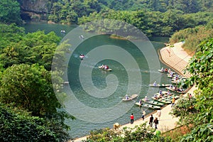 Ferry is parking at a pier for tourists visiting the Trang An Eco-Tourism Complex, which is a complex beauty - landscapes called