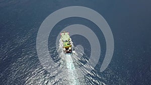 Ferry on the sea, transporting cars: deck of a boat carrying vehicles. Summer sun reflecting off the rippled water