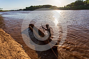 Ferryman on wooden coarse boat on mystical Omo river, Ethiopia
