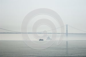 Ferrys crossing the Tagus river in a foggy morning