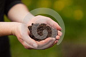 Fertile soil. Female hands hold garden ground. Sustainable agriculture