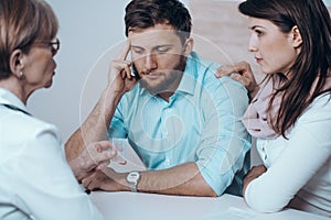 Doctor with man and women together in therapy consult session of inability to get pregnant photo