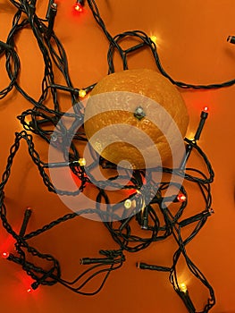 Fesitve Christmas background with garland lights and tangerine