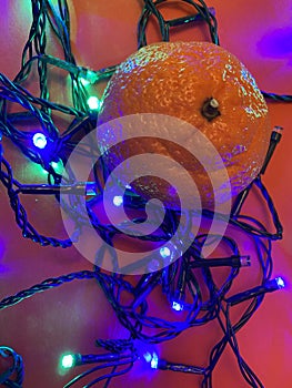 Fesitve Christmas background with garland lights and tangerine