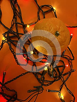 Fesitve Christmas background with garland lights and tangerine