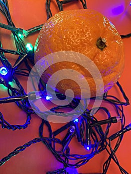 Fesitve Christmas background with garland lights and tangerine