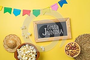 Festa Junina party background with popcorn, peanuts and chalkboard. Brazilian summer harvest festival concept. Top view, flat lay