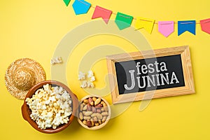 Festa Junina party background with popcorn, peanuts and chalkboard. Brazilian summer harvest festival concept. Top view, flat lay