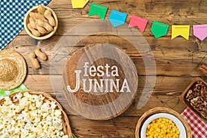 Festa Junina party background with wooden board and traditional food. Brazilian summer harvest festival concept. Top view, flat