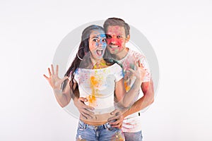 Festival of holi, friendship - young people playing with colors at the festival of holi on white background