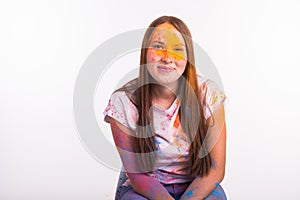 Festival of holi, people concept - young woman dirty in colors smilling and having fun on white background