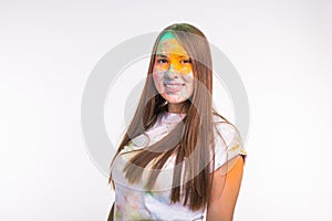 Festival of holi, people concept - young woman dirty in colors smilling and having fun on white background