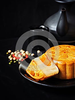 Festival moon cake with hot tea on black background