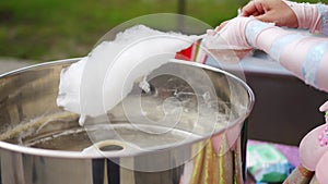 At the festival, a person deftly creates cotton candy. cotton candy machine