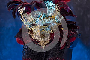 Festival Red golden venetian carnival mask with feathers on a d