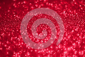 Festive abstract red glitter texture background with shiny sparkle. Colorful defocused background with glittering and sparkling