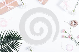 Festive arrangement: boxes with gifts, ribbons and flowers on white table