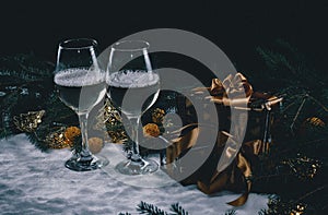The festive atmosphere of Christmas is created on a greeting card with the help of spruce branches, champagne a gift and