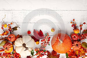 Festive autumn decor from pumpkins, berries and leaves on a white  wooden background. Concept of Thanksgiving day or Halloween.
