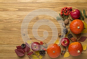 Festive autumn flat lay with pumpkins, berries and leaves on wooden background, top view