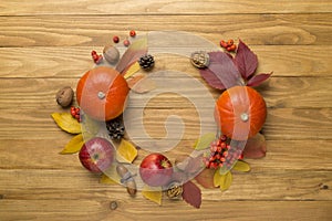 Festive autumn flat lay with pumpkins, berries and leaves on a wooden background, top view