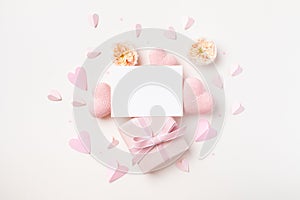 Festive background for Birthday, Woman or Mothers Day. Empty paper card, hearts, rose flowers and gift box on white table