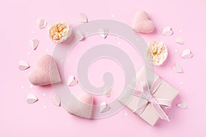 Festive background for Birthday, Woman or Mothers Day. Pink hearts, rose flowers and gift box on table top view. Flat lay