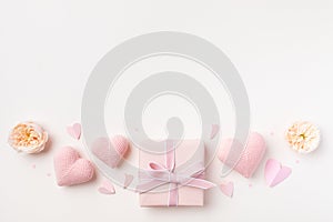 Festive background for Birthday, Woman or Mothers Day. Pink hearts, rose flowers and gift box on table top view. Flat lay