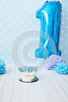 Festive background decoration for birthday with cake, letters saying one and blue balloons in studio, Boy Birthday Cake Smash firs