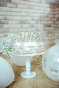 Festive background decoration for birthday with cake, white gypsophila flowers and white balloons in studio, girl Birthday .Cake
