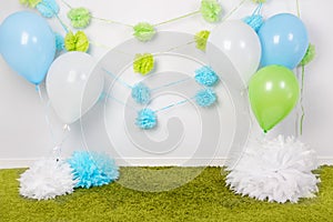 Festive background decoration for first birthday celebration or easter holiday with blue, green and white paper flowers, balloons