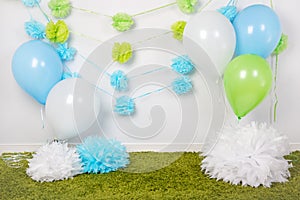 Festive background decoration for first birthday celebration or easter holiday with blue, green and white paper flowers, balloons