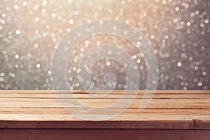 Festive background with empty wooden table over glitter bokeh lights