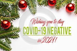 Festive background made of Christmas decorations with message `Wishing you to stay COVID-19 Negative in 2021`