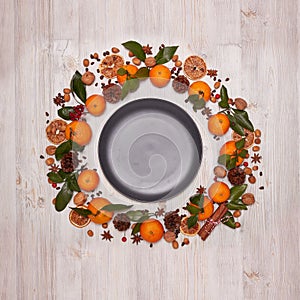Festive background with mandarins, nuts, spices and empty plate