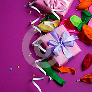 Festive background of purple material colorful balloons streamers confetti box gift Top view flat lay copy space