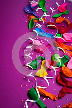 Festive background of purple material colorful balloons streamers confetti box gift Top view flat lay copy space
