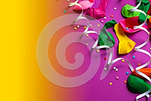Festive background of purple material colorful balloons streamers confetti Top view flat lay copy space