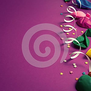 Festive background of purple material colorful balloons streamers confetti Top view flat lay copy space