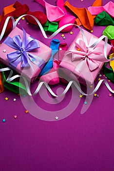 Festive background of purple material colorful balloons streamers confetti tow boxes gift Top view flat lay copy space