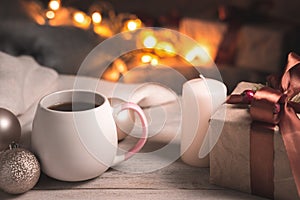 Festive background in warm coffee tones with a Cup of coffee and a gift in a cozy Christmas atmosphere. photo