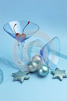 Festive blue martini cocktail glasses with Christmas ornaments - vertical