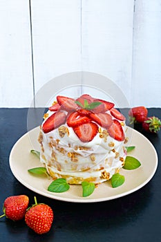 A festive cake with fresh strawberries, cream, decorated with mint leaves