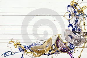 Festive Carnival background with masks, beads and copy space on