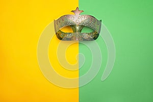 Festive Carnival mask on green and yellow background.