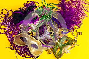 Festive Carnival masks and beads on yellow background